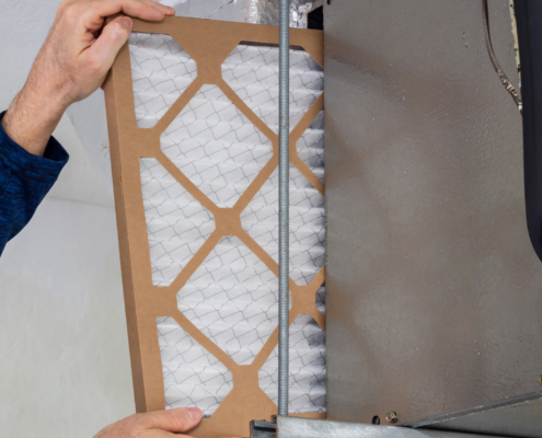HVAC service technician changing dirty indoor air filter