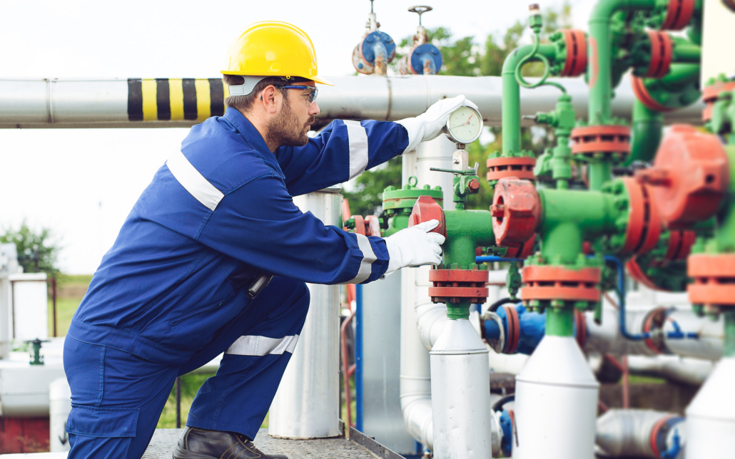 Side view of a maintenance man doing work on industrial equipment