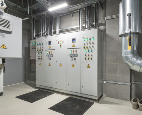 The control room displays advanced electrical panels and monitoring systems