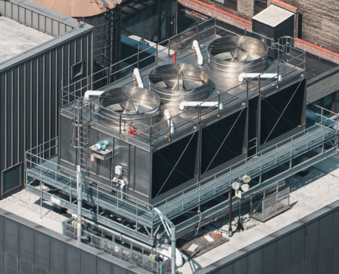 A large industrial building with a large cooling tower on top
