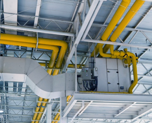 Ceiling with ventilation pipes and lights in industrial building