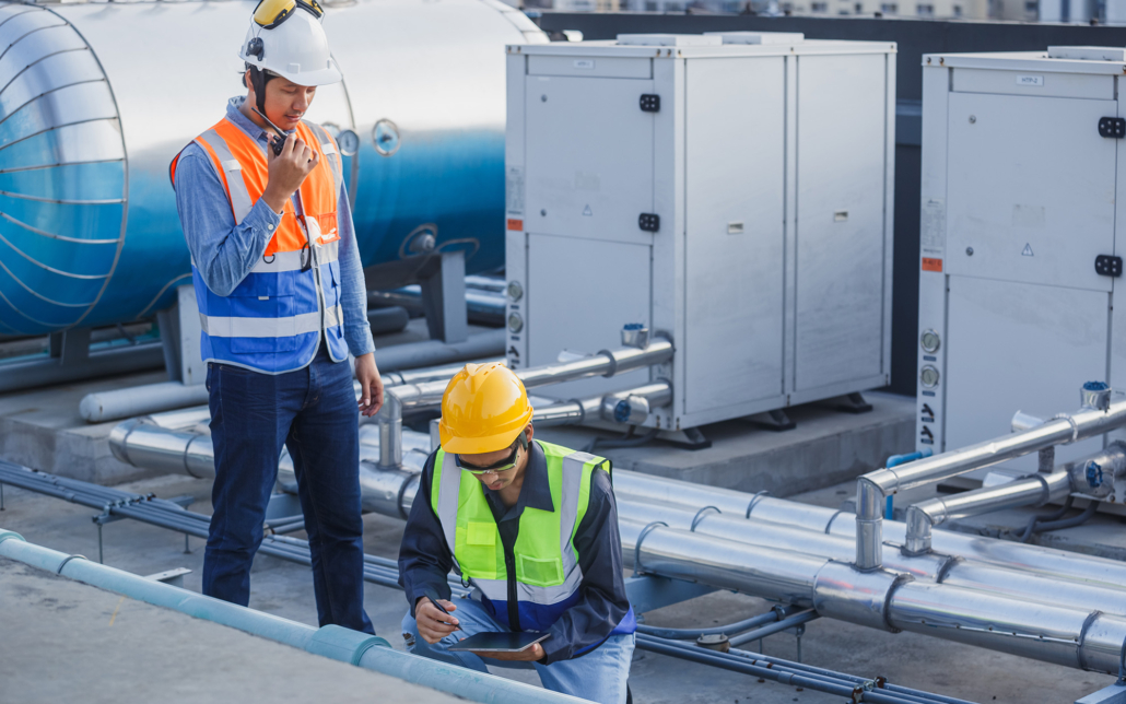 Two HVAC professionals working on roof unit