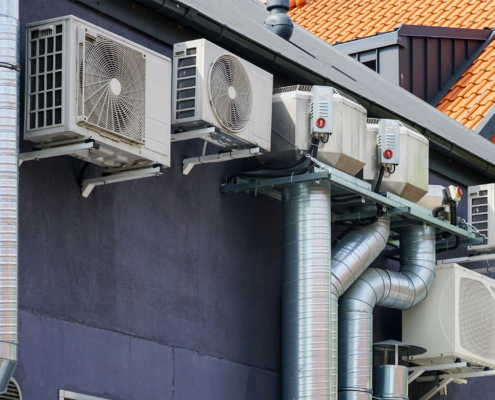 Modern HVAC Air Conditioning and Ventilation System Units Mounted on Building Exterior Wall
