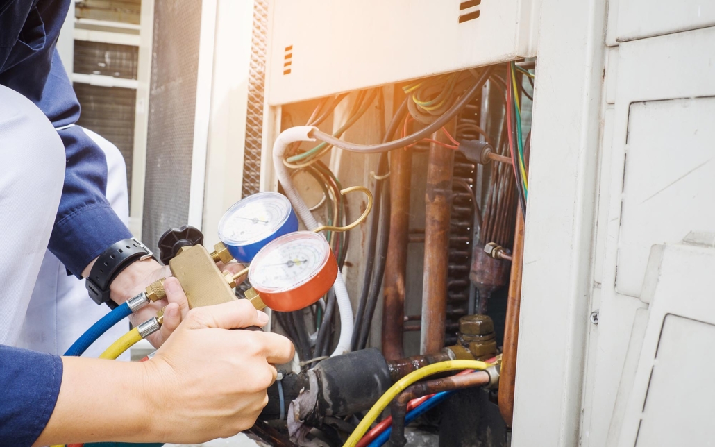 worker measuring pressure of commercial hvac unit