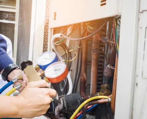 worker measuring pressure of commercial hvac unit