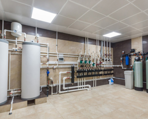 Large maintenance room with boilers and pipes